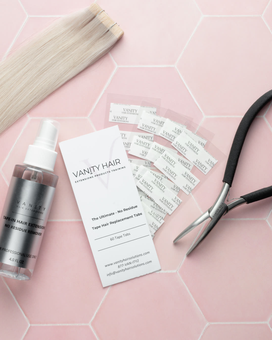 Blonde tape-in weft beside the no-residue remover, replacement tape tab card and pliers